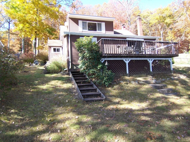 rear view of house with stairs, a yard, a chimney, and a wooden deck