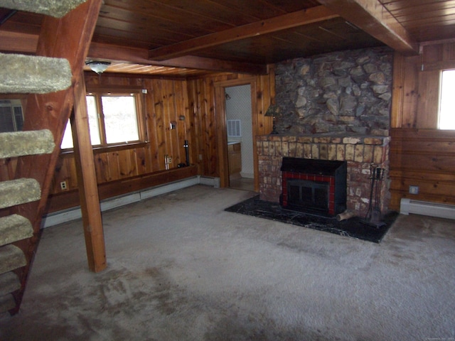 carpeted living area with beamed ceiling, wood walls, wooden ceiling, and a brick fireplace