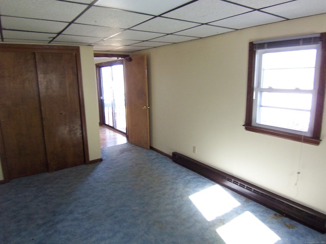 spare room featuring carpet floors, plenty of natural light, baseboard heating, and a paneled ceiling