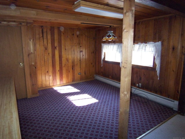 unfurnished room featuring a baseboard radiator, wooden walls, and carpet flooring