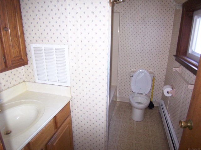 bathroom with visible vents, wallpapered walls, baseboard heating, vanity, and walk in shower