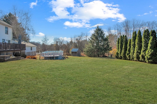 view of yard featuring a storage shed, a garden, and an outdoor structure