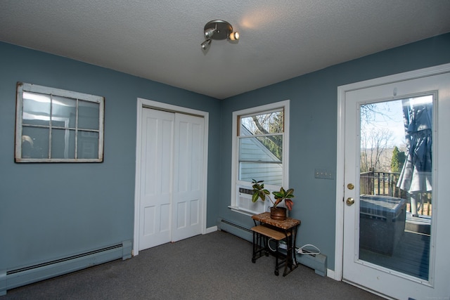 entryway featuring carpet, a baseboard radiator, baseboards, and a textured ceiling