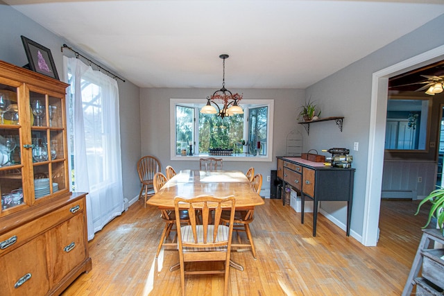 dining space featuring a healthy amount of sunlight, light wood-type flooring, and a baseboard radiator