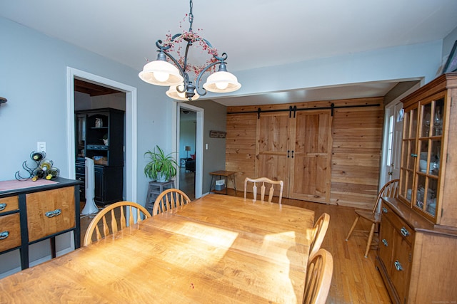 dining room featuring light wood-type flooring and an inviting chandelier