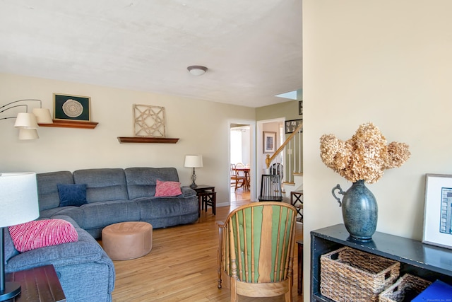 living area with stairway, wood finished floors, and baseboards