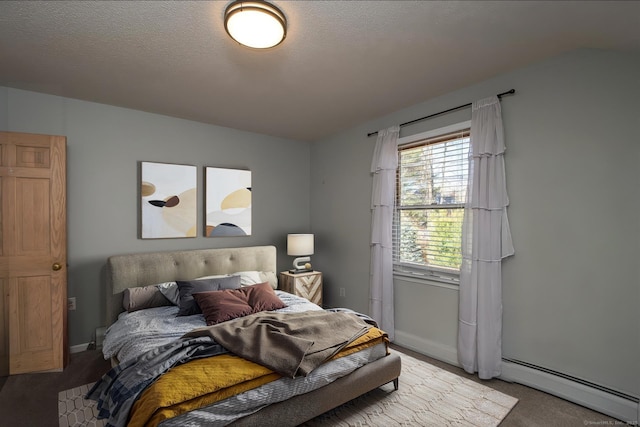 carpeted bedroom with baseboards, baseboard heating, and a textured ceiling