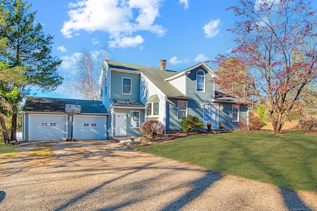 view of front of house featuring a garage, driveway, a chimney, and a front lawn