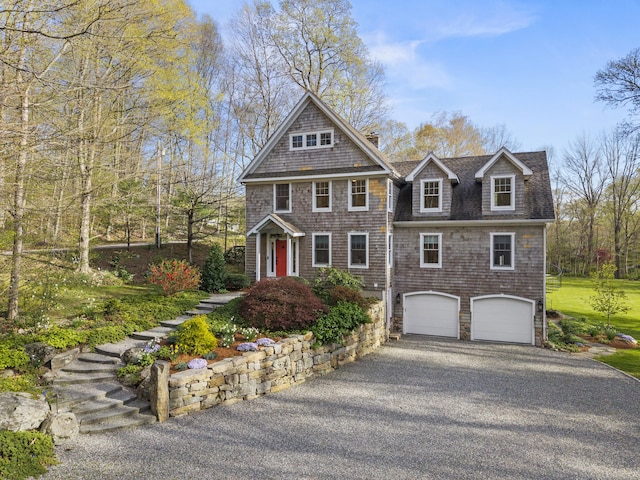 shingle-style home with a garage, aphalt driveway, a chimney, and a shingled roof