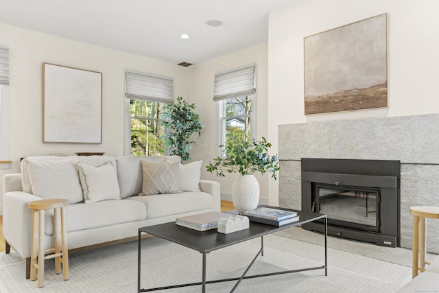 living area featuring visible vents, recessed lighting, and a glass covered fireplace