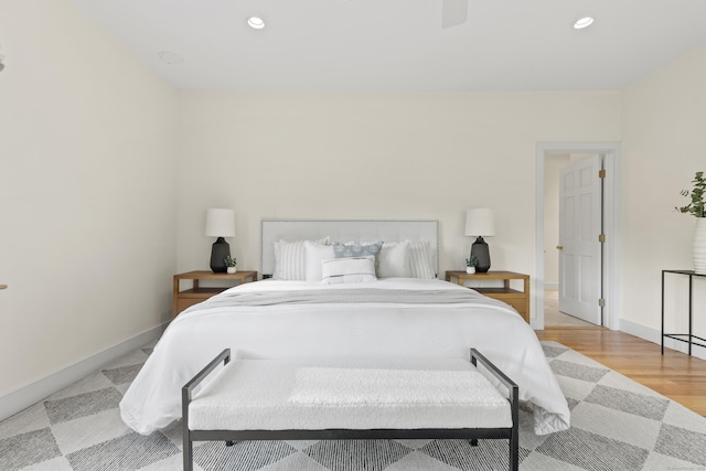 bedroom with baseboards, recessed lighting, and light wood-style flooring