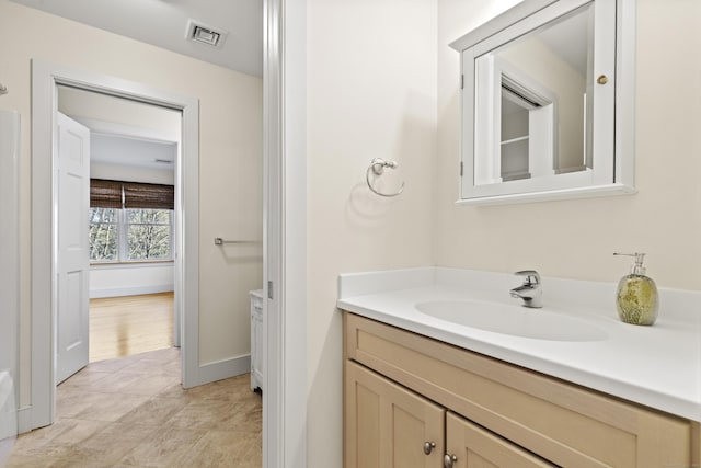 bathroom featuring vanity, baseboards, and visible vents