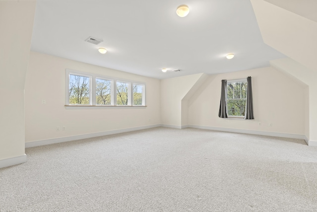 bonus room featuring baseboards, light carpet, and visible vents