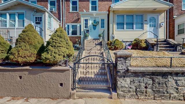 view of front of house featuring a gate, brick siding, and fence