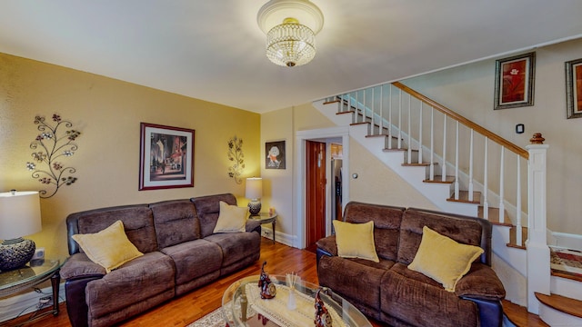 living room with stairs, wood finished floors, and baseboards