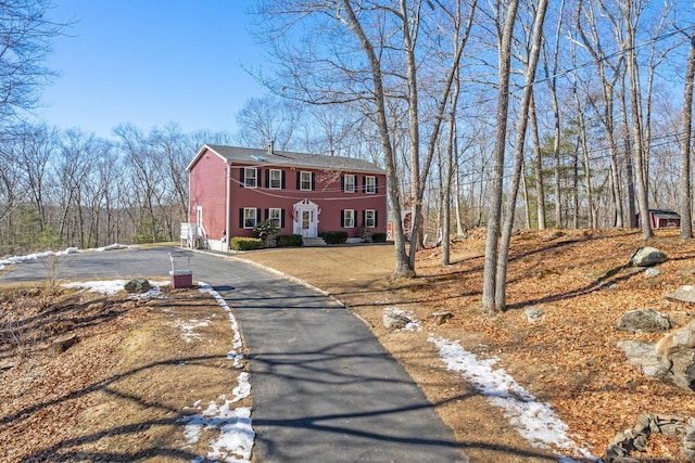 colonial house with aphalt driveway and brick siding