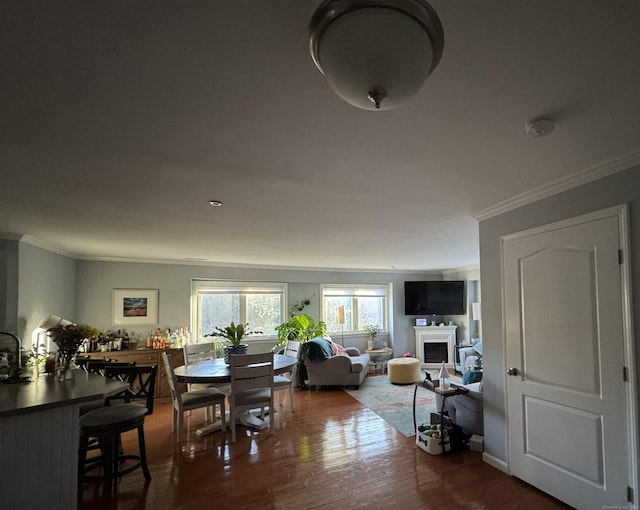 dining room with crown molding, a fireplace, and wood finished floors