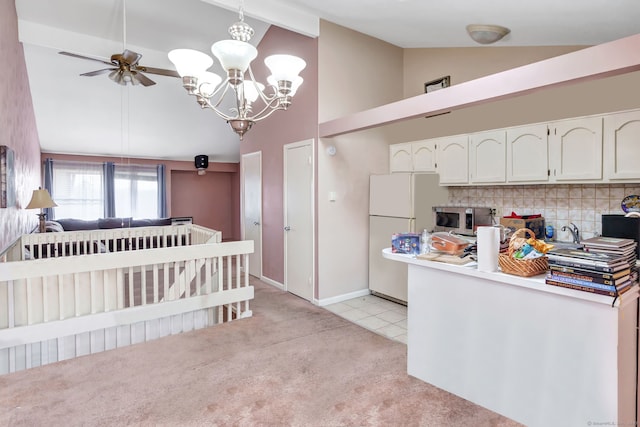 kitchen with light carpet, white cabinets, decorative backsplash, stainless steel microwave, and freestanding refrigerator