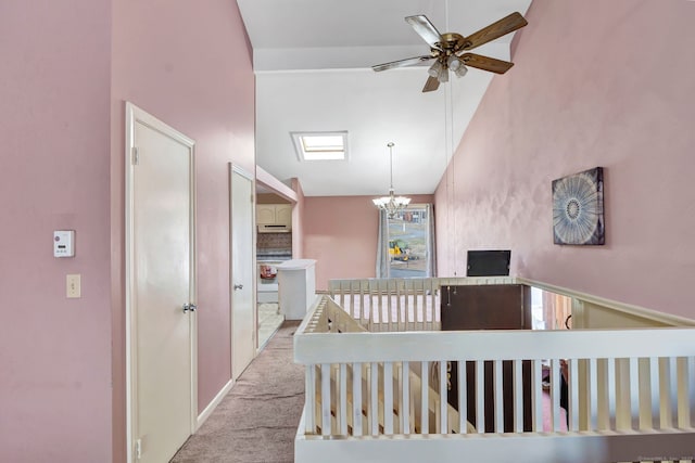 hallway with vaulted ceiling, carpet flooring, an upstairs landing, and a notable chandelier