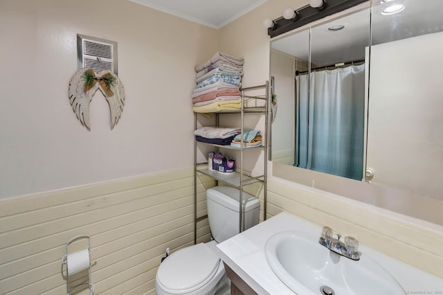 bathroom with a shower with shower curtain, a wainscoted wall, vanity, and toilet