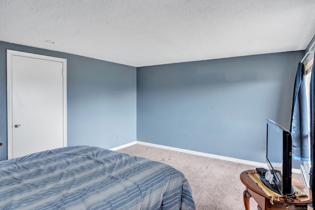 carpeted bedroom with a textured ceiling and baseboards