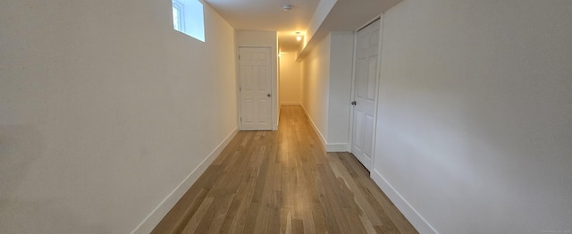 hallway with wood finished floors and baseboards