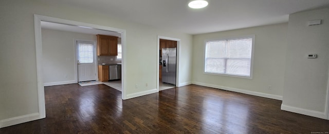 unfurnished living room with dark wood-style floors and baseboards