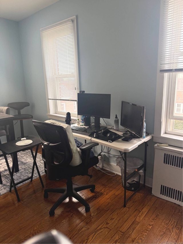 office area with wood finished floors and radiator