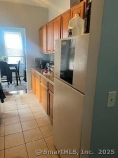 kitchen featuring brown cabinets, light countertops, and light tile patterned flooring