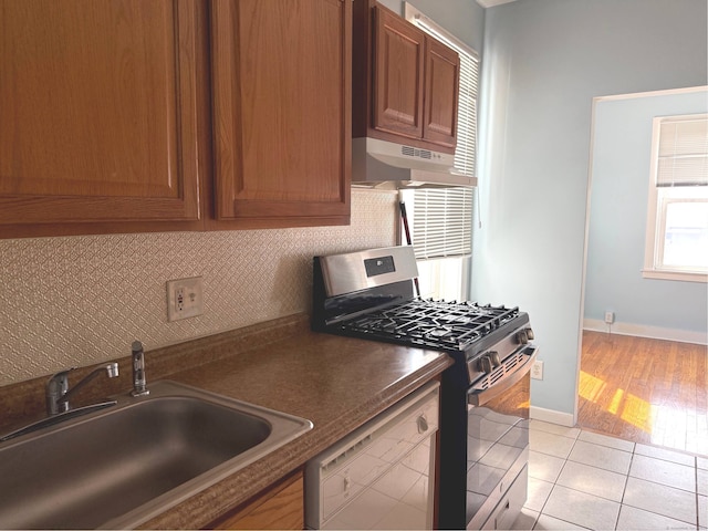 70 Strawberry Hill Ave Apt 3-3B, Stamford, CT 06902 - kitchen featuring gas range, under cabinet range hood, dark countertops, white dishwasher, and tasteful backsplash