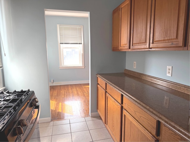 70 Strawberry Hill Ave Apt 3-3B, Stamford, CT 06902 - kitchen featuring gas stove, dark countertops, brown cabinetry, and light wood finished floors