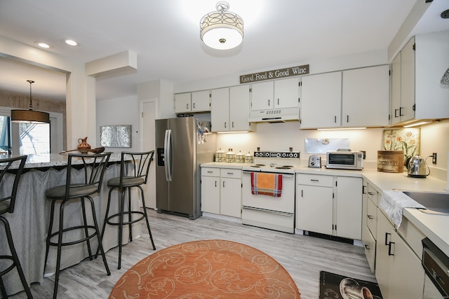 kitchen with white appliances, under cabinet range hood, white cabinetry, and light countertops