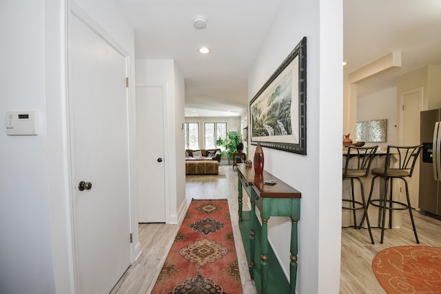 hall with light wood finished floors and recessed lighting