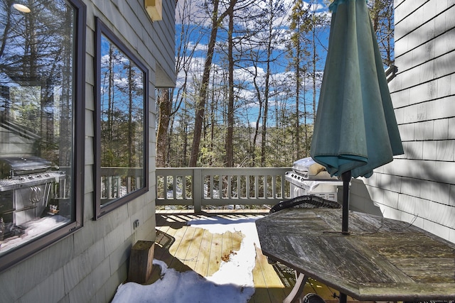 wooden terrace featuring grilling area and outdoor dining space