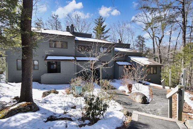 snow covered house with a chimney