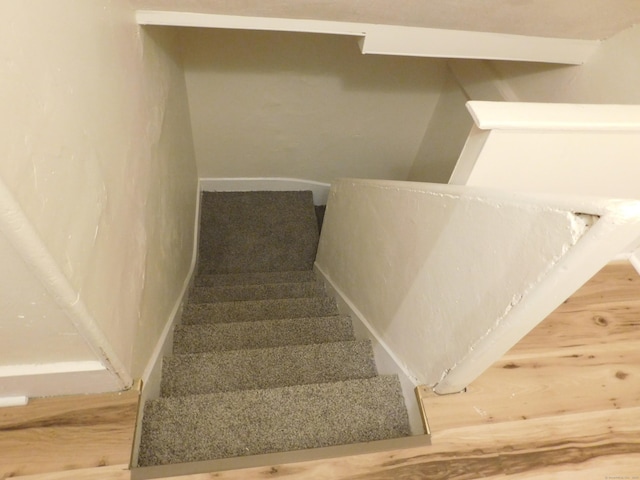 stairs featuring baseboards and carpet flooring