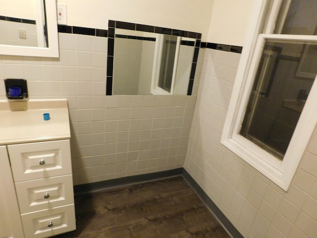 bathroom with tile walls, wood finished floors, and vanity