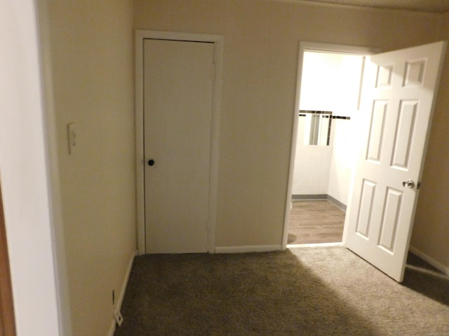 hall featuring carpet flooring and baseboards