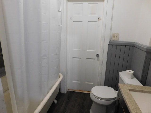 bathroom featuring shower / bath combo with shower curtain, toilet, wood finished floors, and vanity