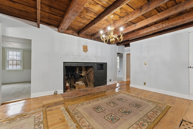 living room with beam ceiling, wooden ceiling, a fireplace, and hardwood / wood-style flooring