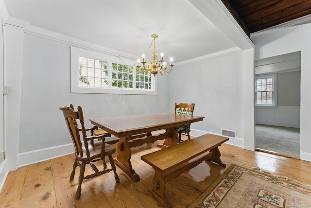 dining space with baseboards, visible vents, hardwood / wood-style floors, and ornamental molding