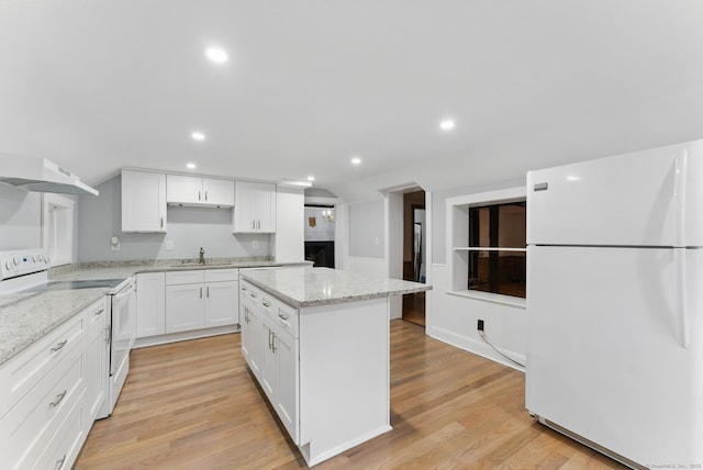 kitchen featuring white appliances, white cabinets, a kitchen island, light wood-type flooring, and a sink