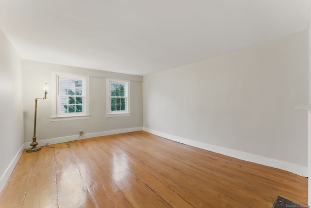 unfurnished room with baseboards and light wood finished floors