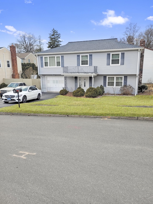 view of front of property with a garage, driveway, and a front yard