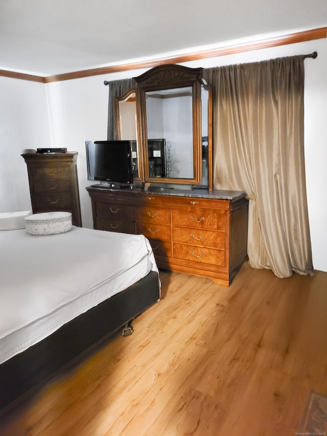 bedroom with light wood-style flooring and ornamental molding