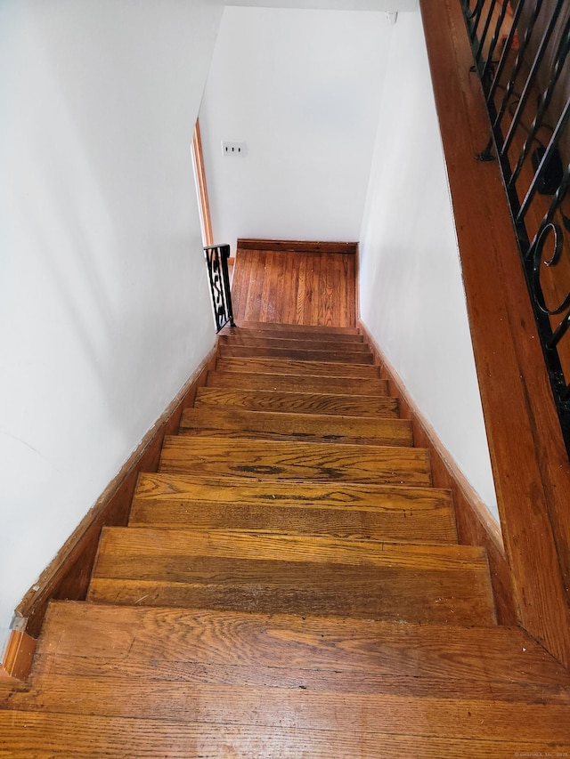 stairs with baseboards and wood finished floors