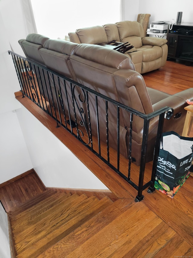 staircase featuring wood finished floors and baseboards