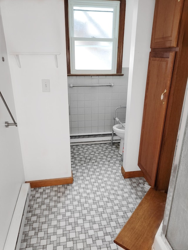 bathroom featuring a baseboard heating unit, a baseboard radiator, tile walls, and toilet