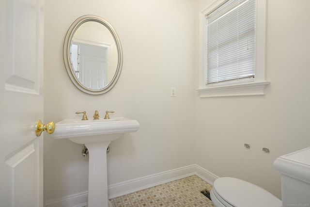 bathroom with tile patterned floors, toilet, and baseboards