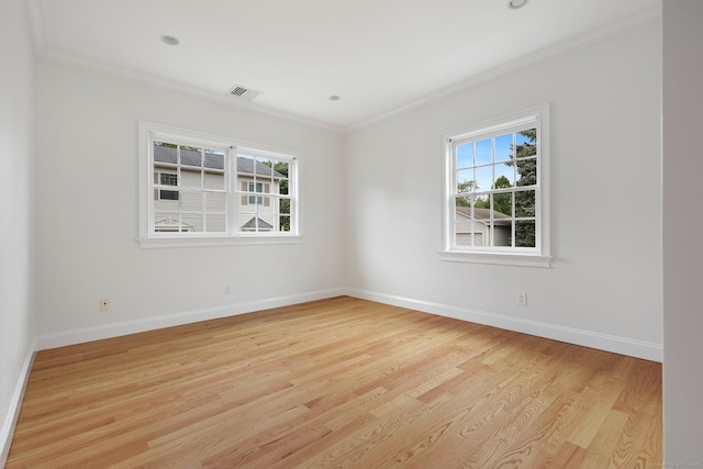 spare room featuring a wealth of natural light, visible vents, light wood-style flooring, and baseboards